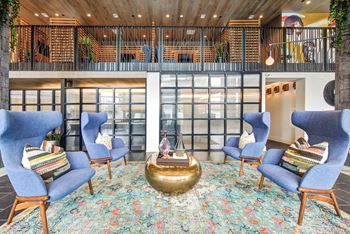 A lobby with blue chairs and a round table